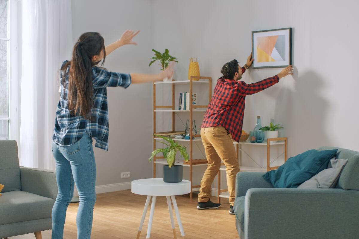 Couple hanging up a photo.