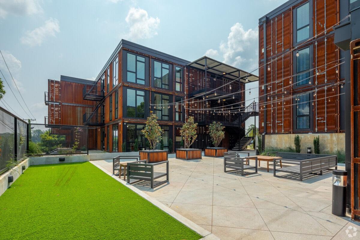 The community courtyard at 83 Freight in Nashville has outdoor string lights, plenty of seating, and a green space overlooking Downtown Nashville.