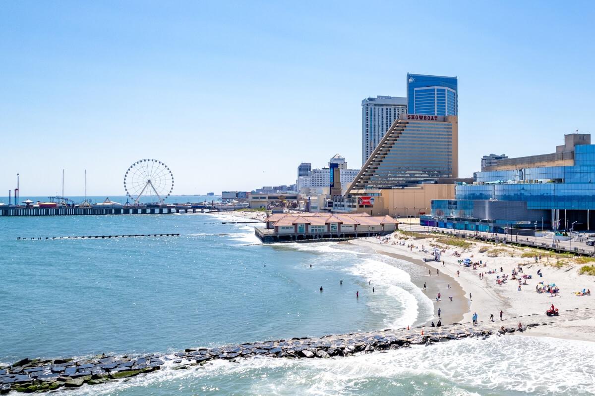 The Atlantic City boardwalk has a Ferris wheel and a sandy beach.