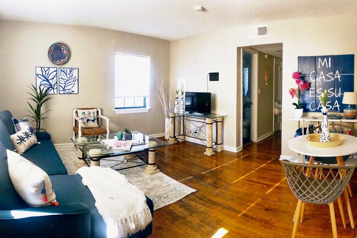 A panoramic view of a unit at 35 Gillham shows a living and dining area with hardwood flooring and blue accents.