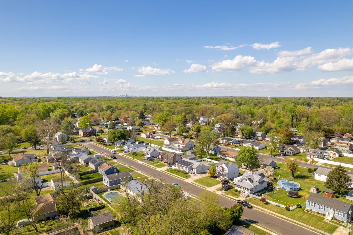 A neighborhood in Lindenwold is surrounded by trees and the Philadelphia skyline is in the distance.