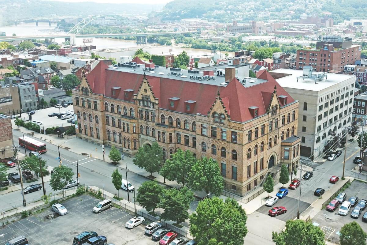 An aerial view of Fifth Avenue School Lofts shows the Victorian Gothic architecture.