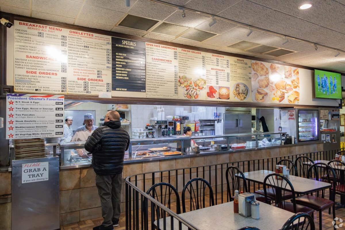 A man studies the menu at Valois Restaurant, which advertises a few of former president Barack Obama's favorites.