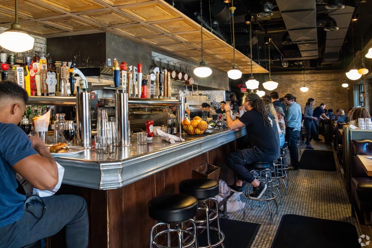 Customers sit at the bar at Au Cheval.