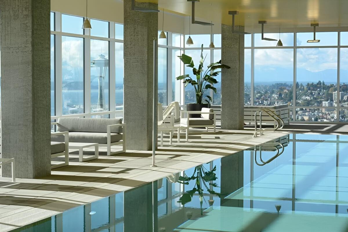 Lounge chairs and a pool are in a fully enclosed rooftop.