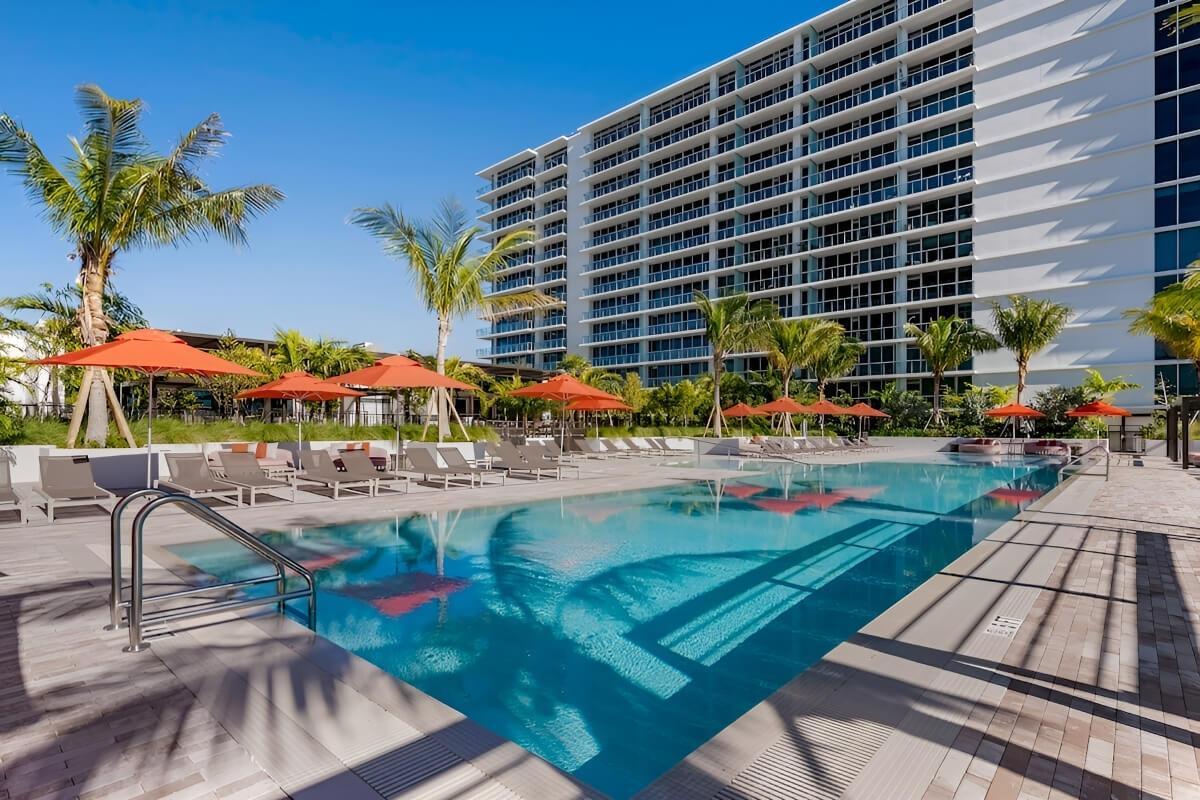 Lounge chairs under pools sit next to a rooftop pool.