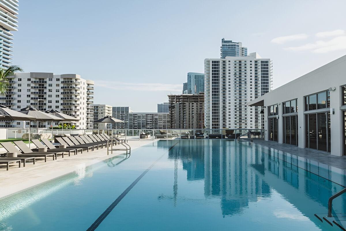 The rooftop pool stretches out in front of the fitness center and is lined with lounge chairs.