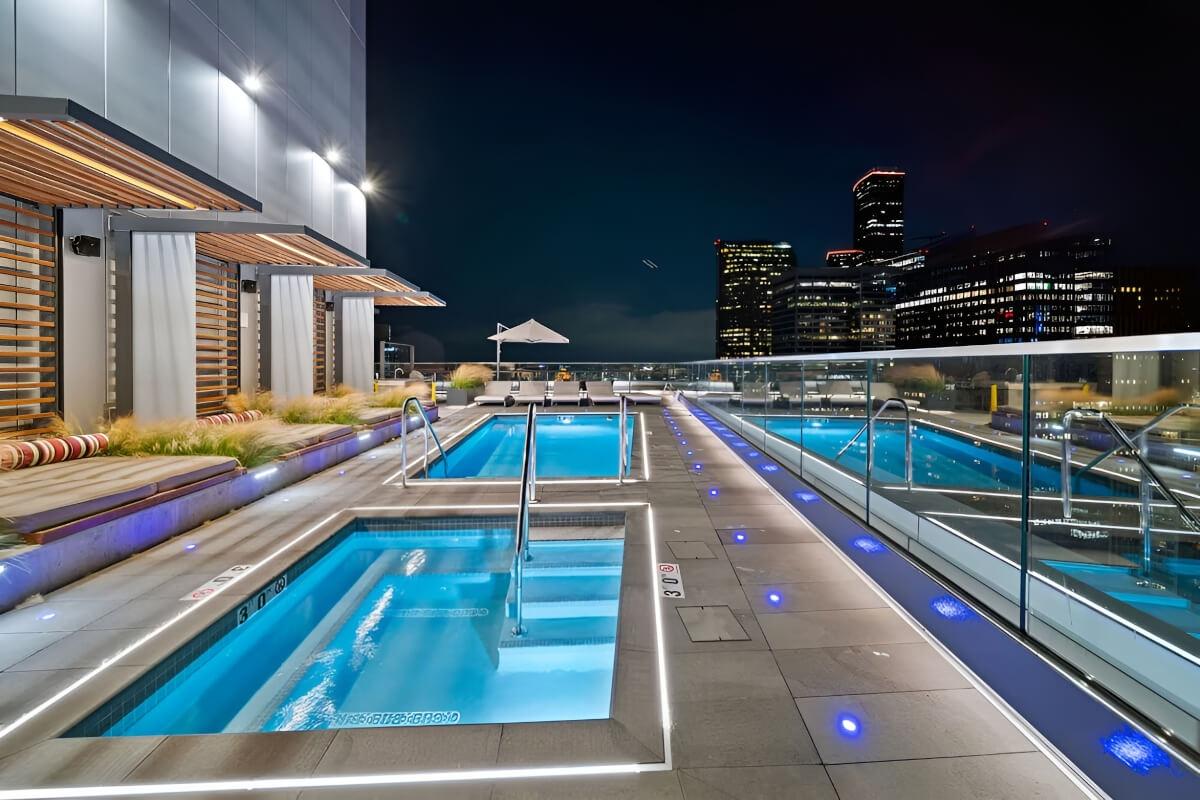 Cabanas line a rooftop pool and hot tub.