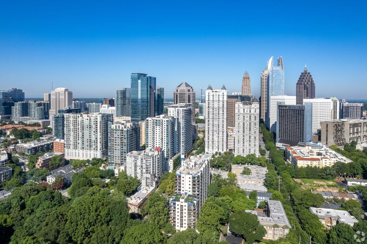 The Midtown Atlanta skyline towers over lush greenery.