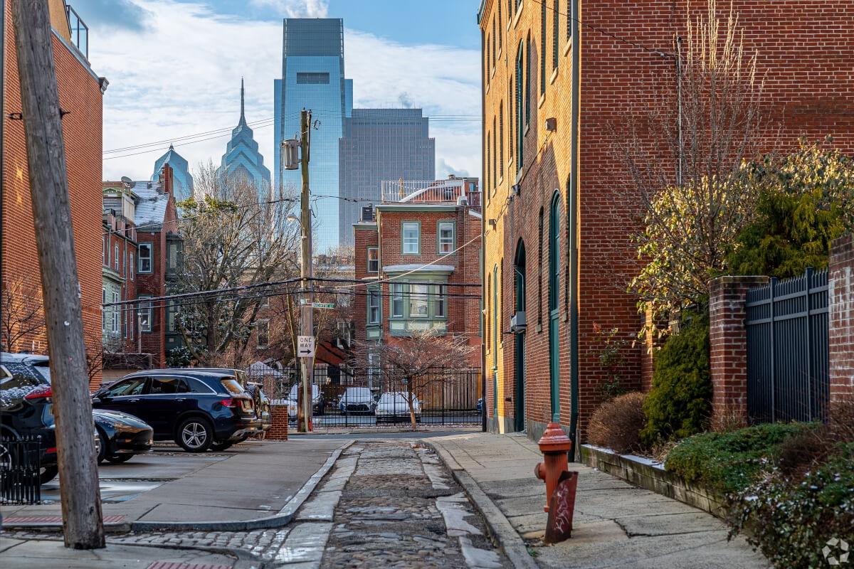 A cobblestone street in Fairmount-Art Museum in Philadelphia with the skyscrapers in the background.