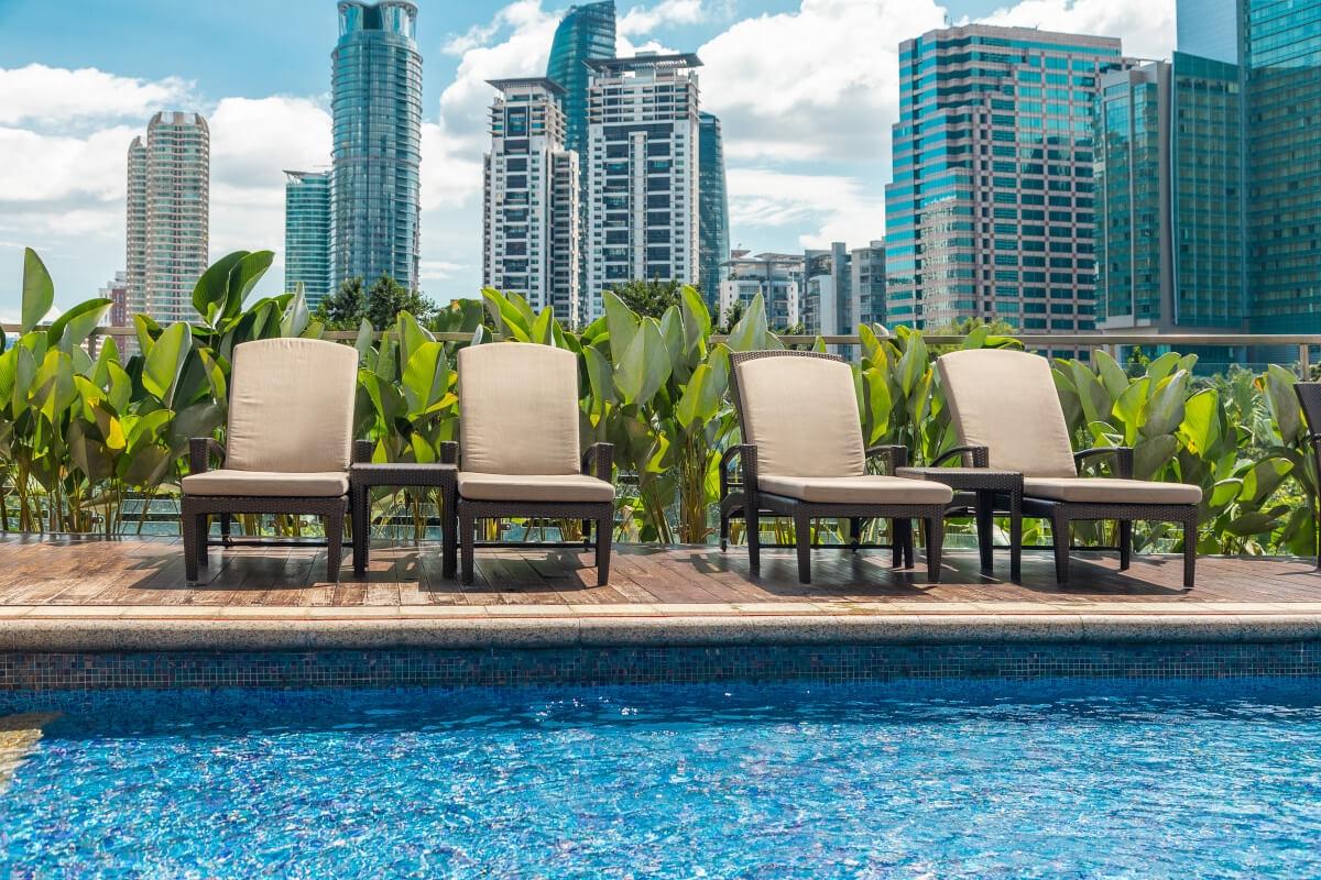 Pool and lounge chairs with green plants in the background