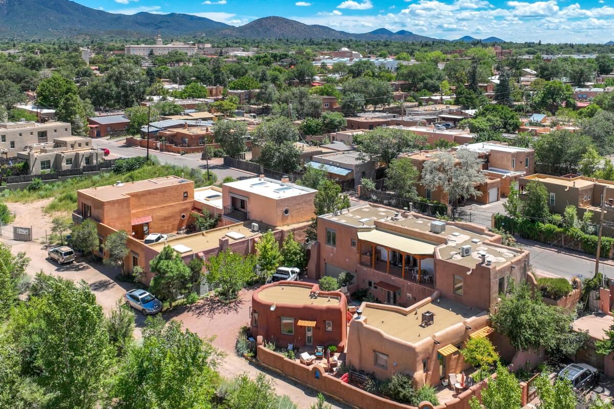 An aerial view of adobe houses in Downtown Santa Fe with mountains in the background.