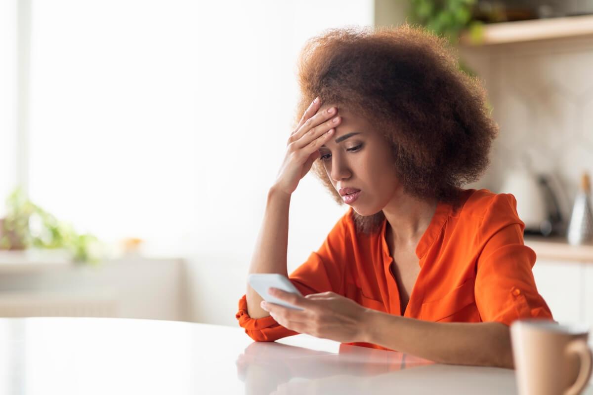 Woman staring at her phone in frustration.
