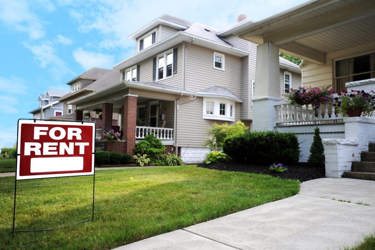 House with 'For Rent' sign in the yard