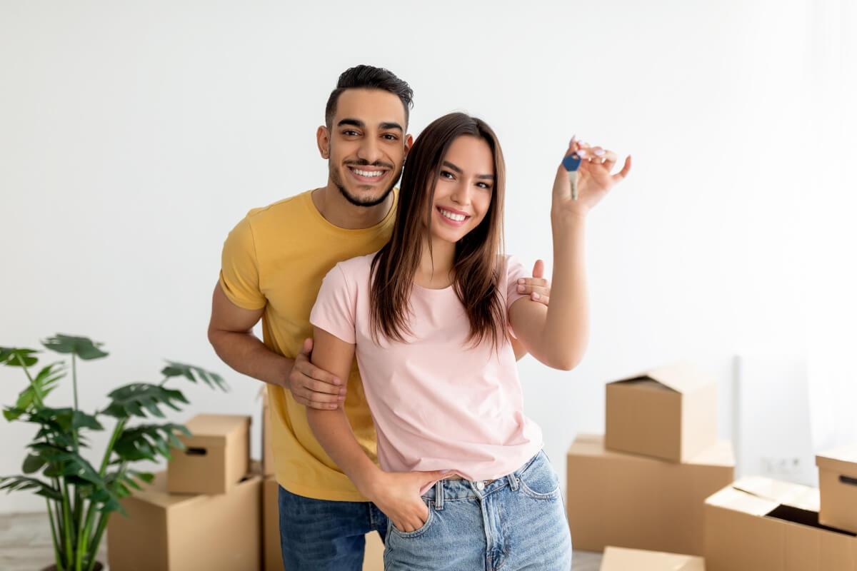 Tenants pose in front of moving boxes in home
