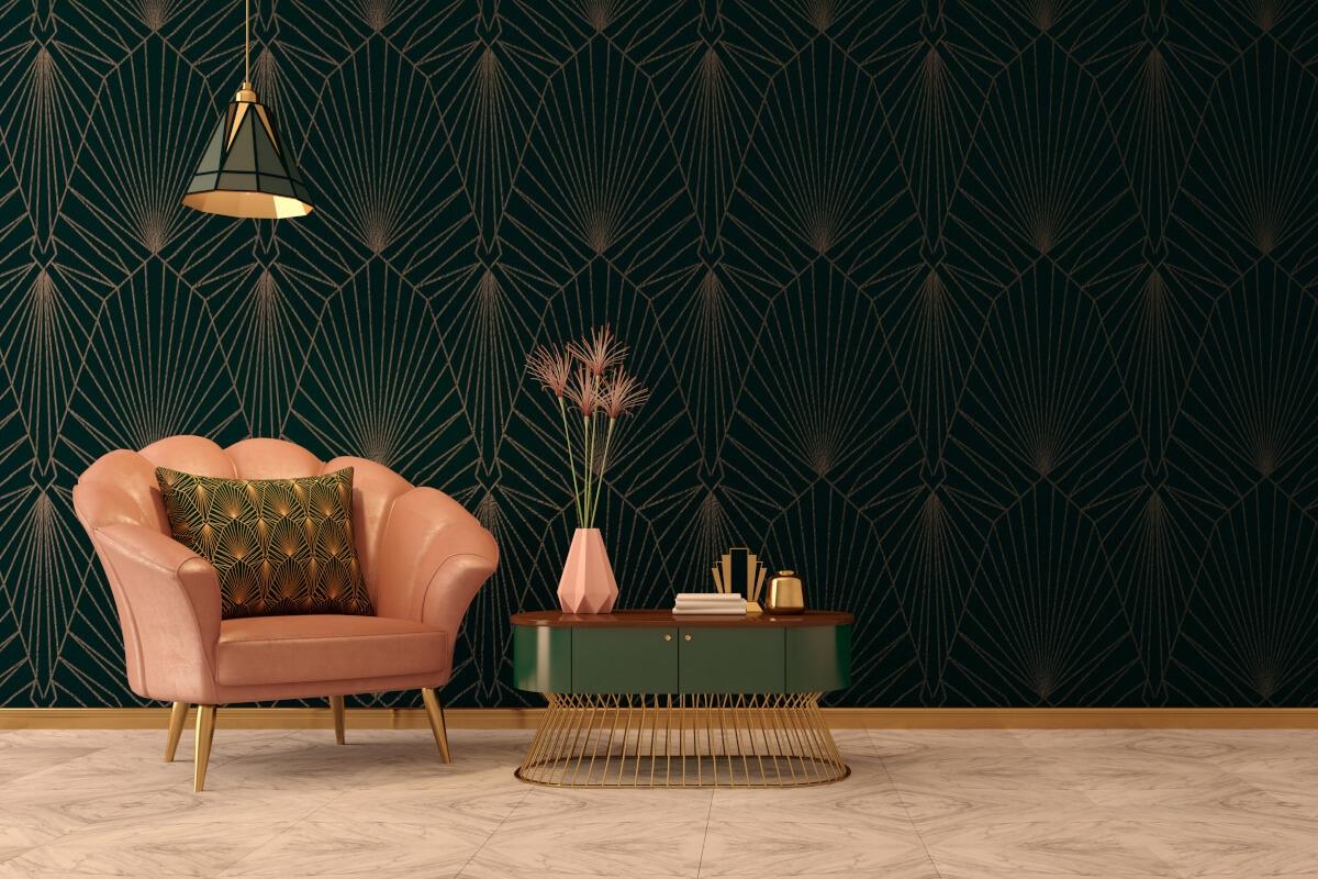 A salmon-colored armchair sits in front of a wall covered in Art Deco wallpaper.