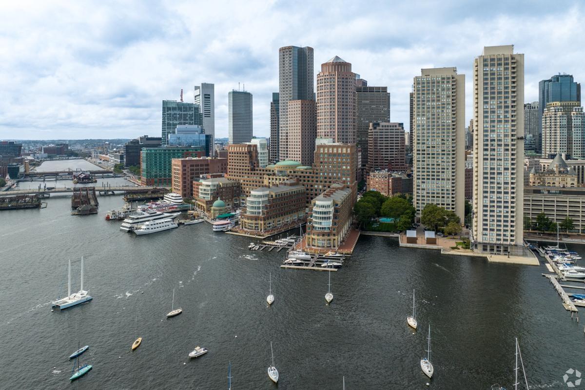 Waterfront buildings in Boston, MA as the water is packed with boats.