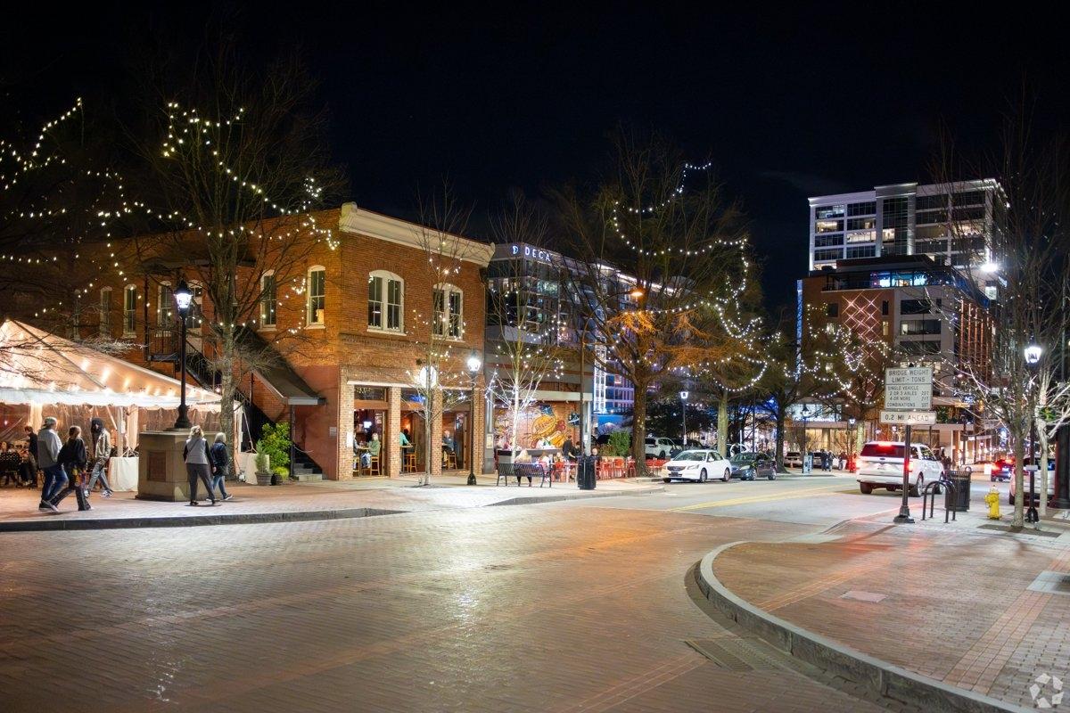 Night view of downtown Greenville, SC with twinkling lights and bustling restaurants — ideal for renters wanting vibrant city life in the South.
