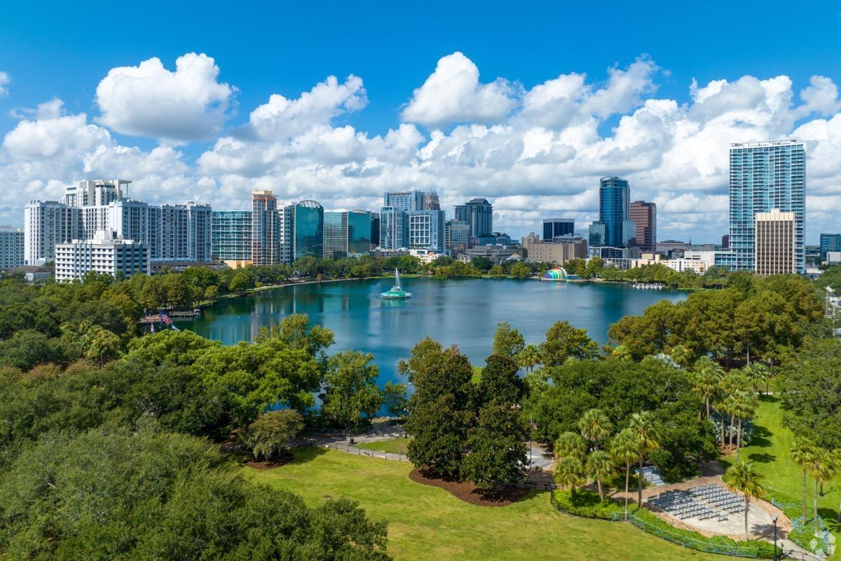 Cityscape of Orlando, Florida featuring Lake Eola and surrounding high-rises.