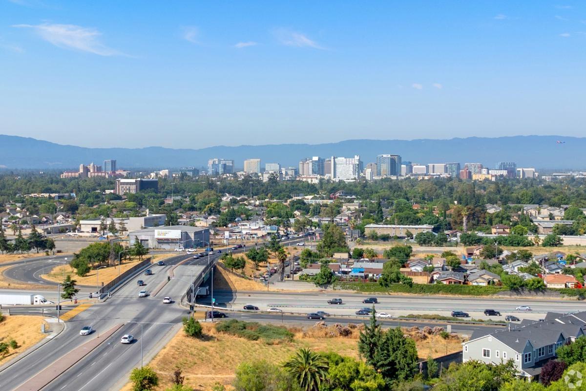 Skyline of San Jose, California with surrounding suburban neighborhoods and major highways, highlighting the mix of urban and residential living.