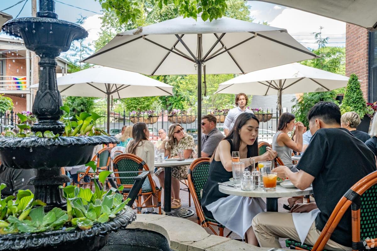 Diners eating outside under umbrellas