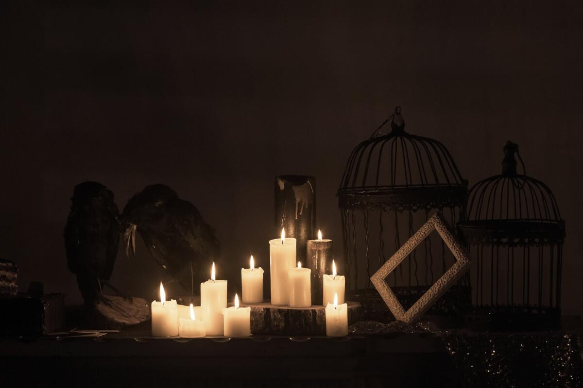 A close-up shot of a fireplace mantel decorated with candles and ravens.