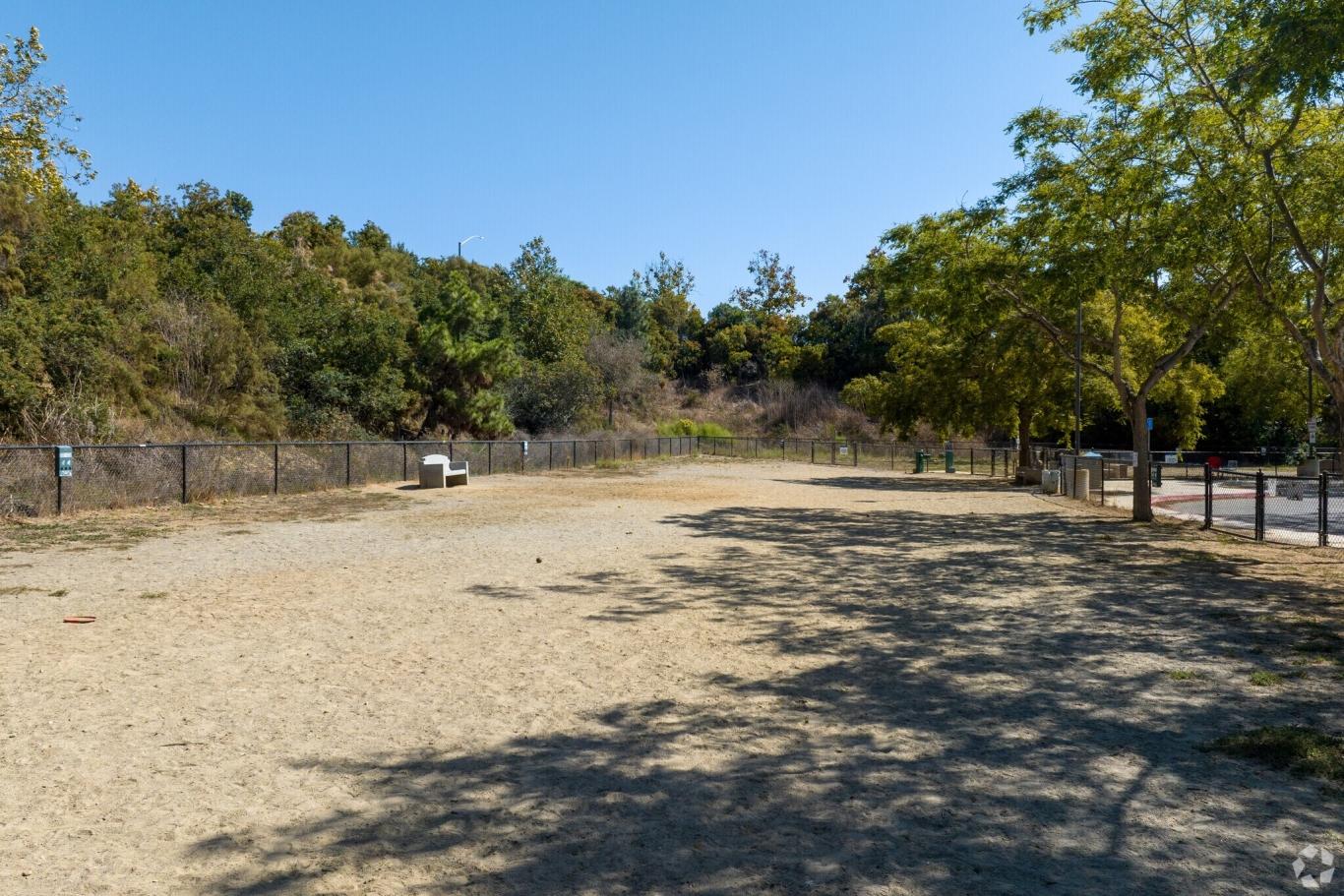 Shaded open space at University City Dog Park in San Diego, featuring fenced areas and seating.