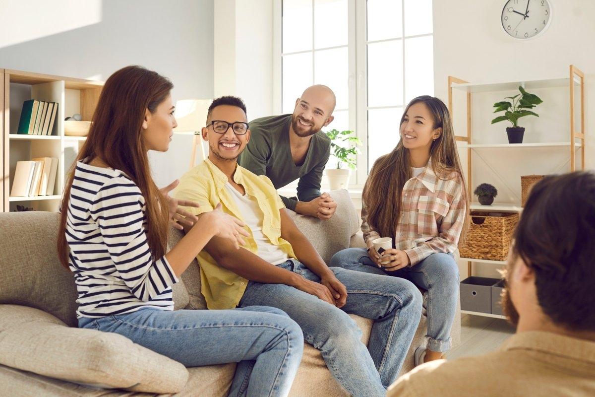 A group house filled with residents conversing in the living room