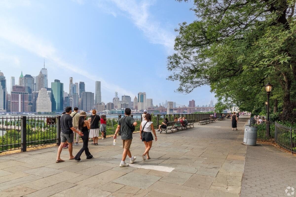 Pedestrians on Brooklyn Heights Promenade look at the Manhattan skyline.