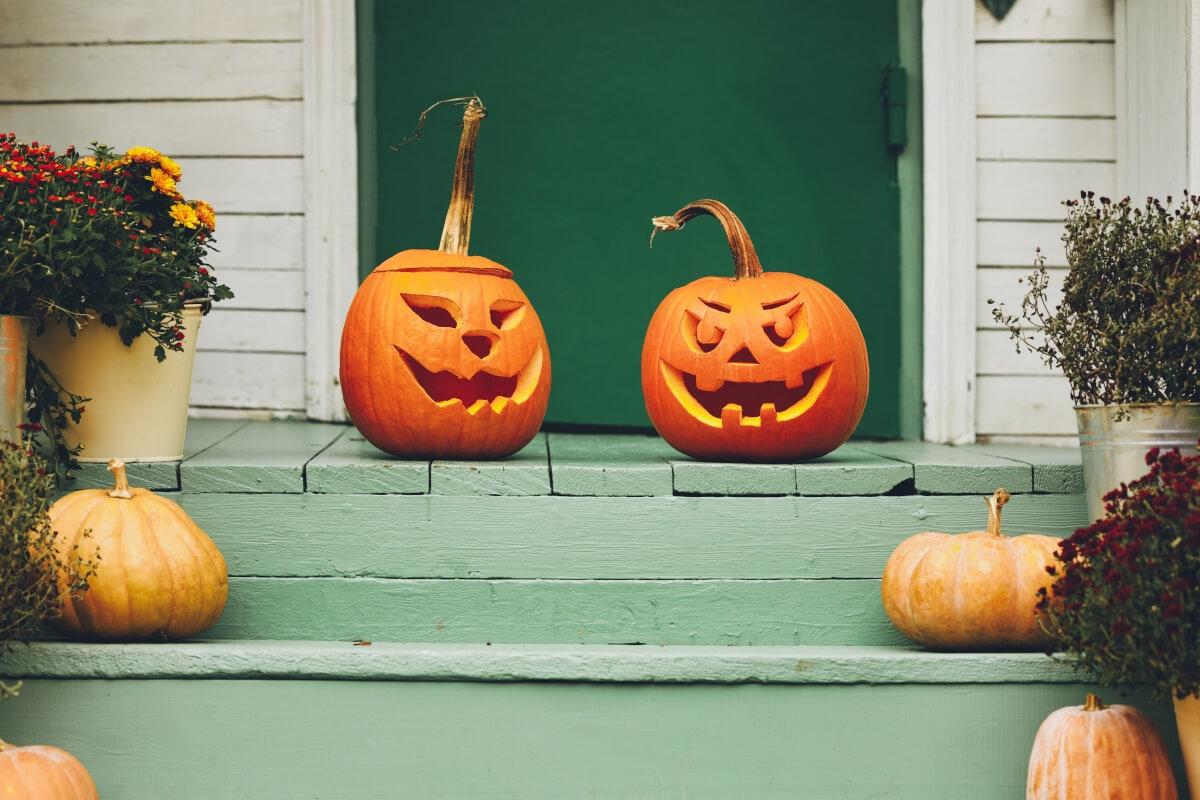 Two jack-o'-lanterns on a front porch.