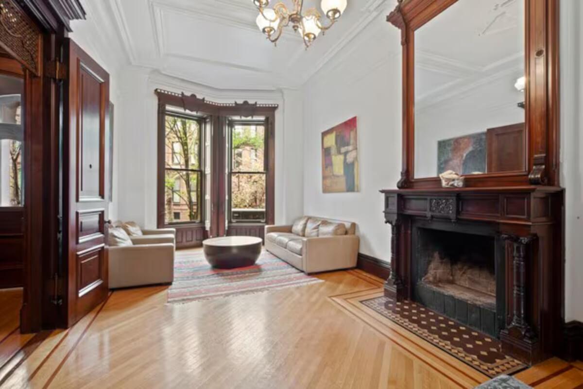 The living room at 189 St. Johns Place has ornate wood trim.
