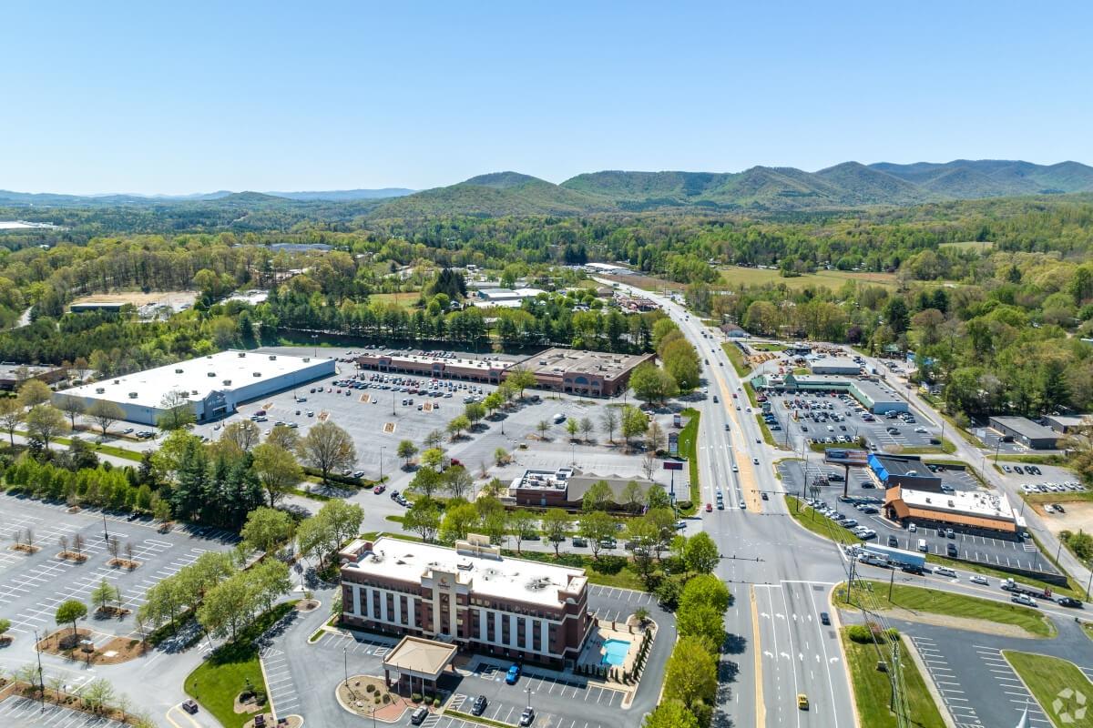 An aerial view of Asheville, NC, with mountains in the distance.