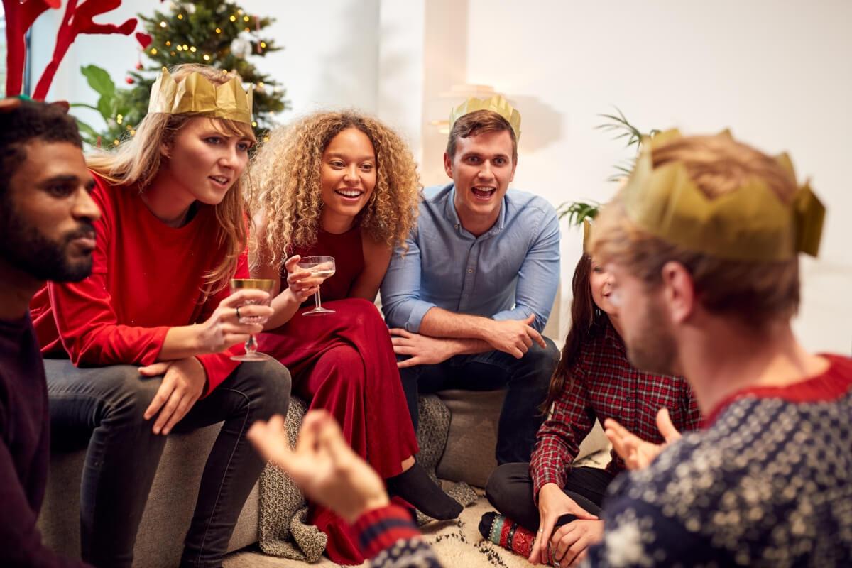 Group of friends gathered on sofas playing holiday games