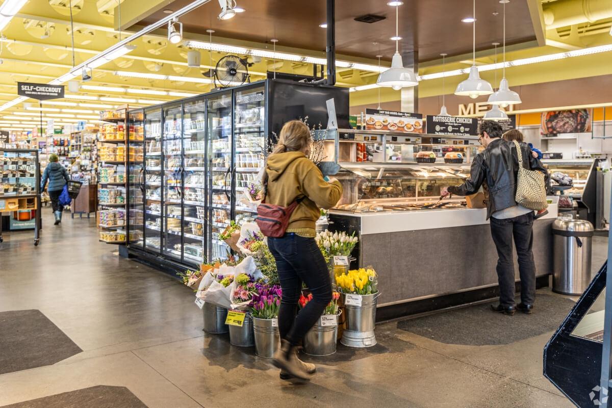 People checking out prepared food at a grocery store.