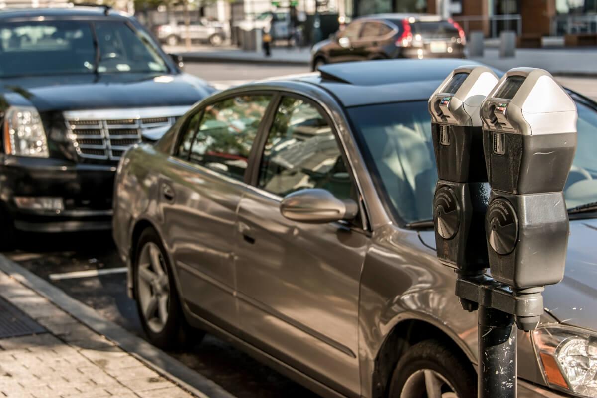 Cars parked in front of meter.