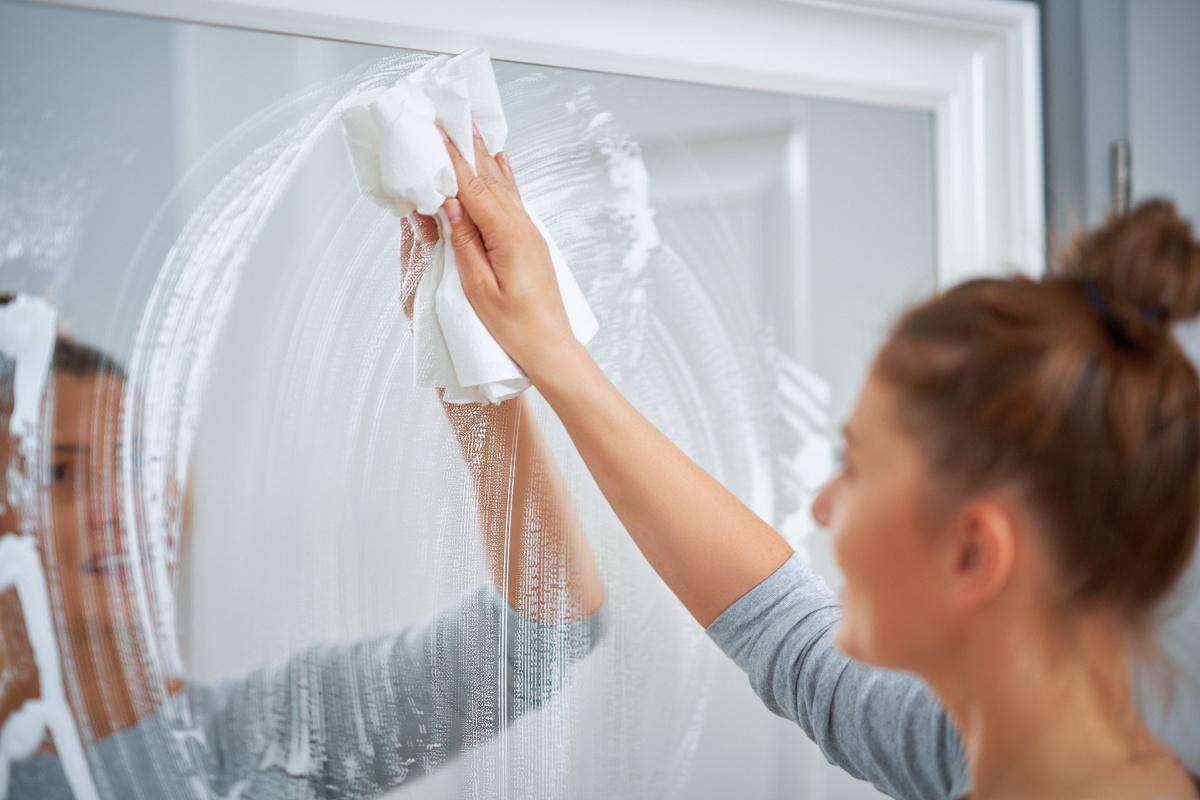 Renter cleans her bathroom mirror.