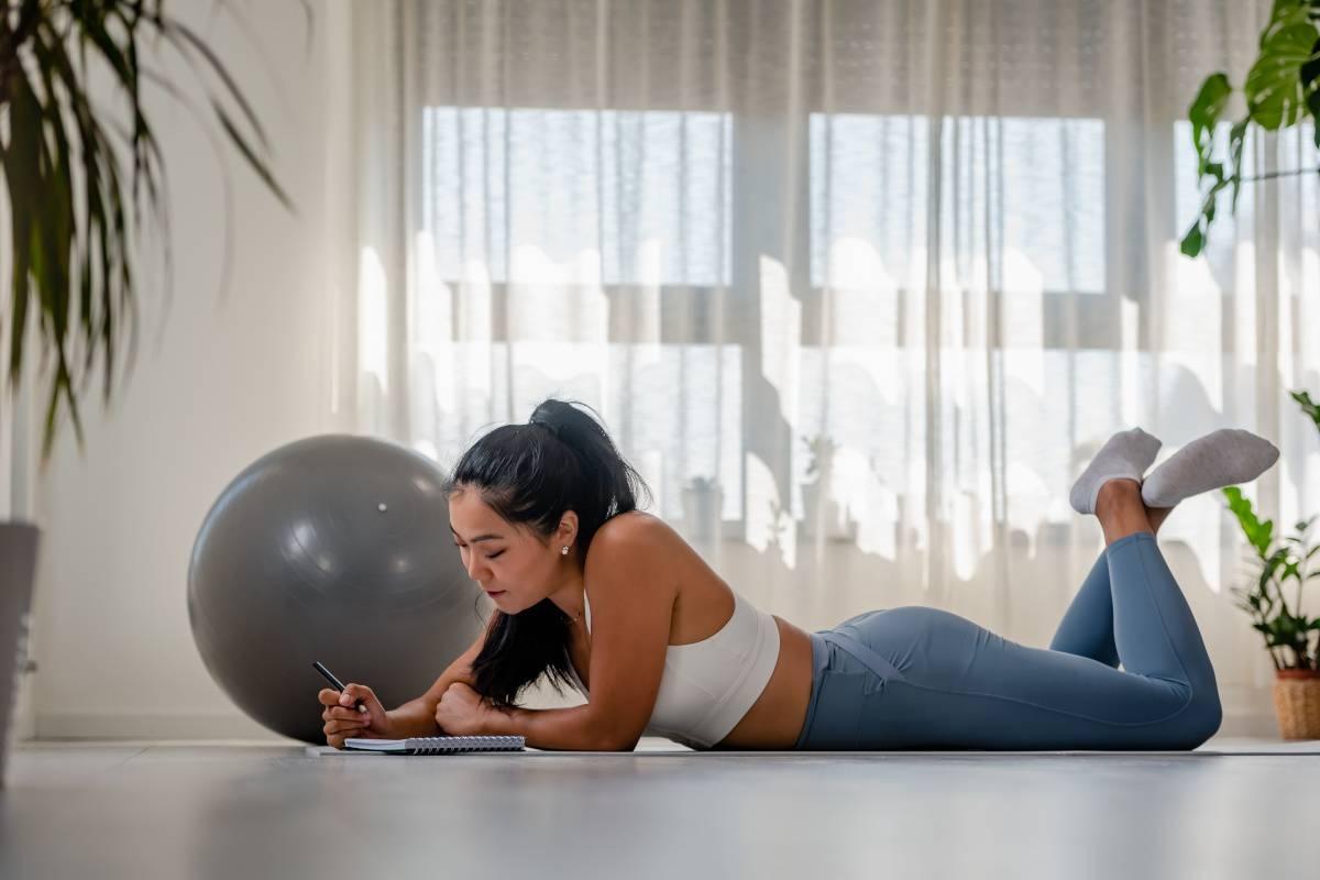 Woman writes New Year's resolutions down post-workout.