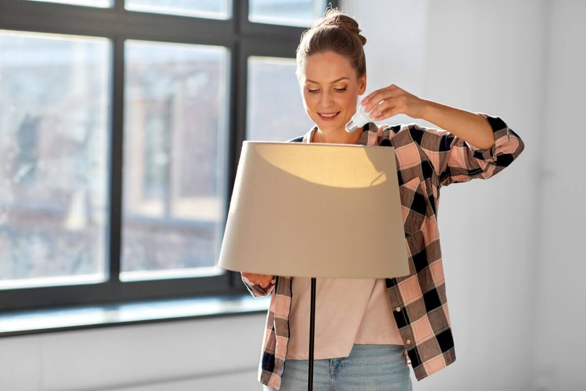 Woman switches a lightbulb in her lamp.
