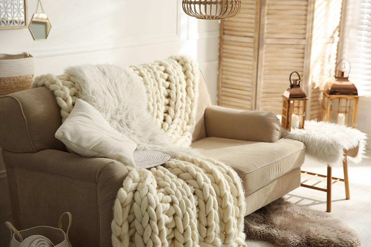 Couch with chunky knit throw.