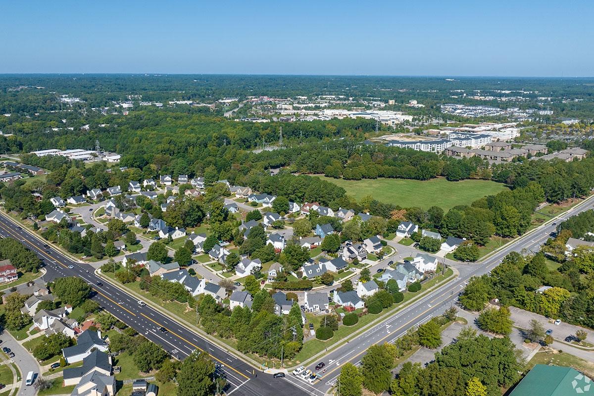 Homes sit in tree-filled neighborhoods with large apartment communities behind them in Triangle Town Center.