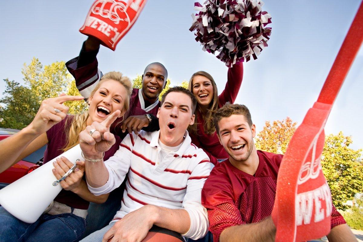 A group of sports fan with raised hands cheering