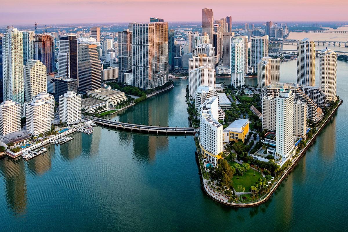 Miami skyscrapers stretch above the water.