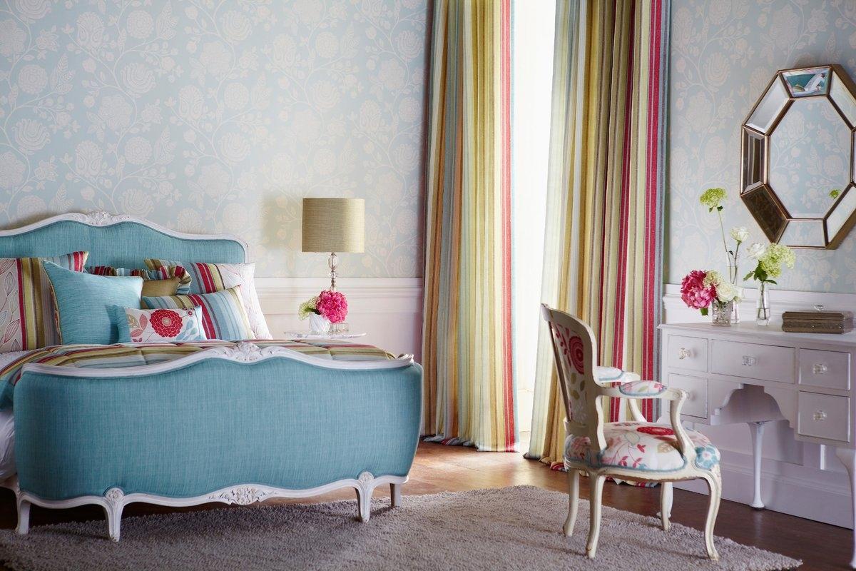 A bedroom of colorful striped curtains and pillows