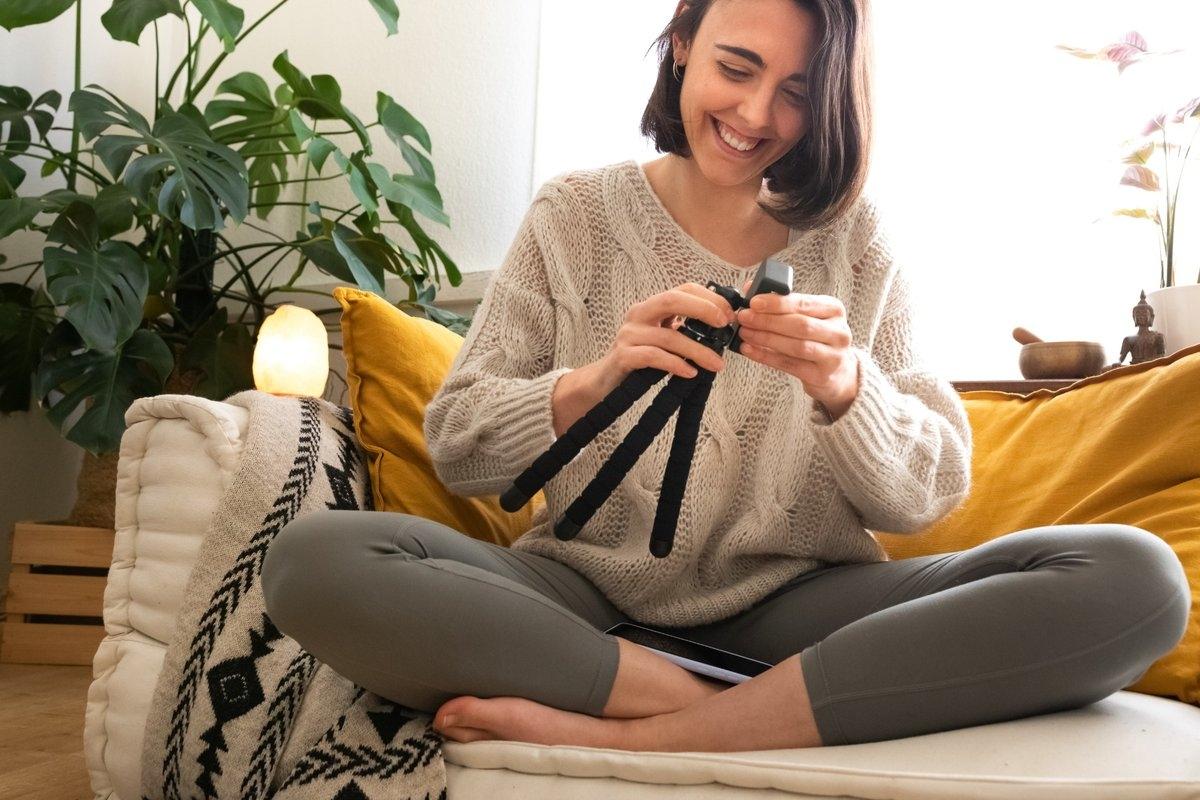 Person sitting on sofa packing up her tripod
