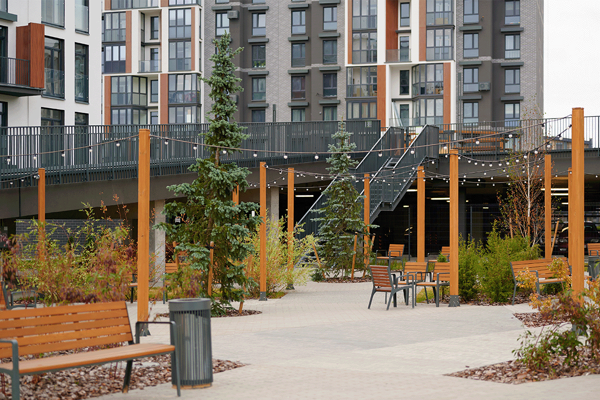 the outside of an apartment community, where the path has string lights and outdoor seating