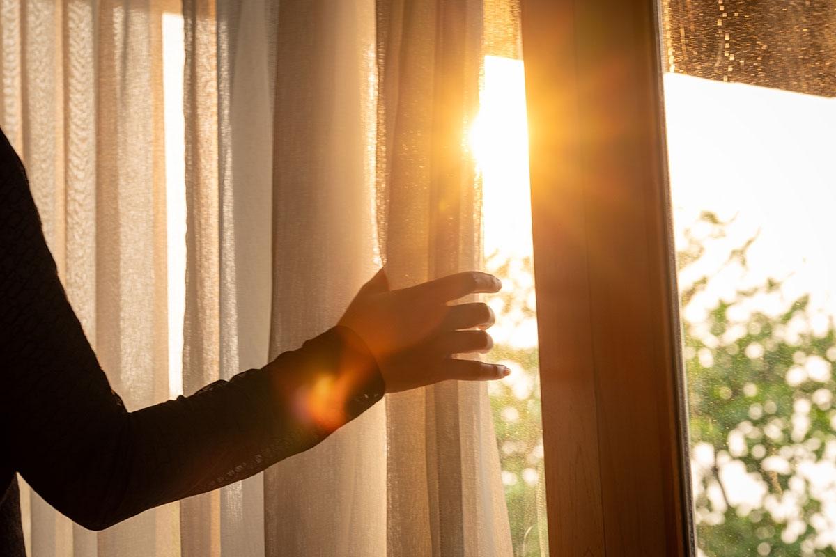Opening curtains to let light in