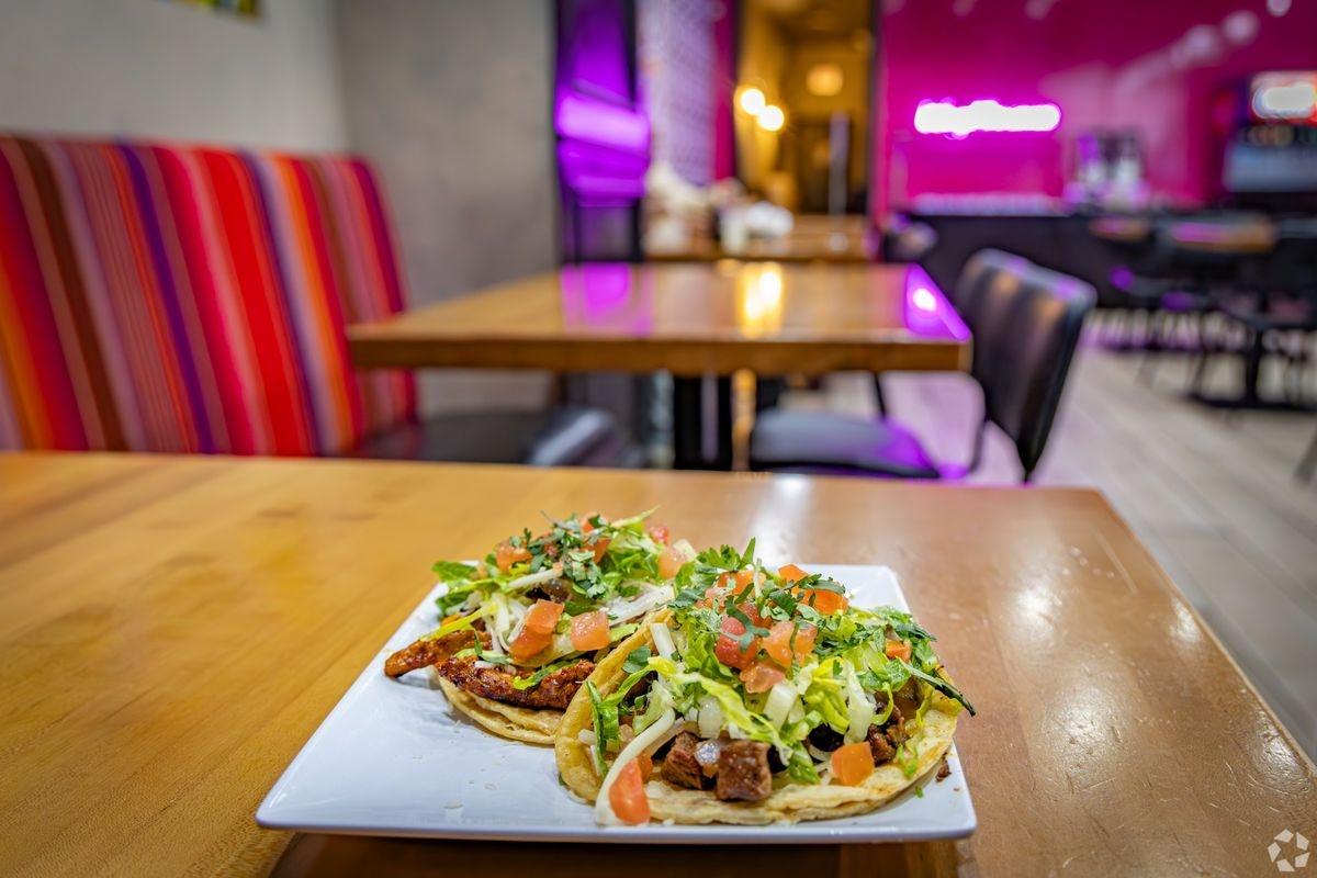 A plate of 3 overstuffed tacos sitting on a plate