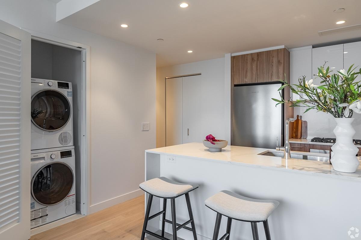 A washer and dryer sit in a closet in a modern apartment.