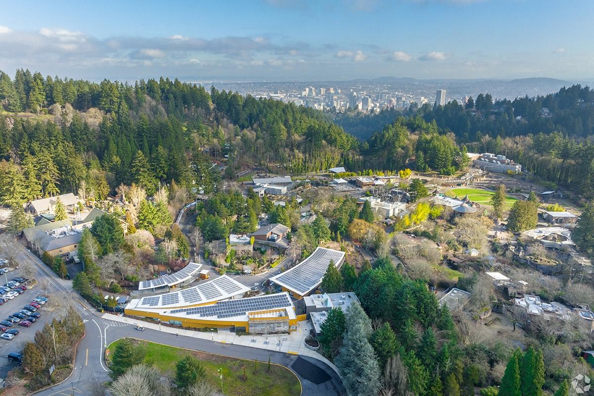 The Oregon Zoo is nestled in between mountains with Downtown Portland in the background.
