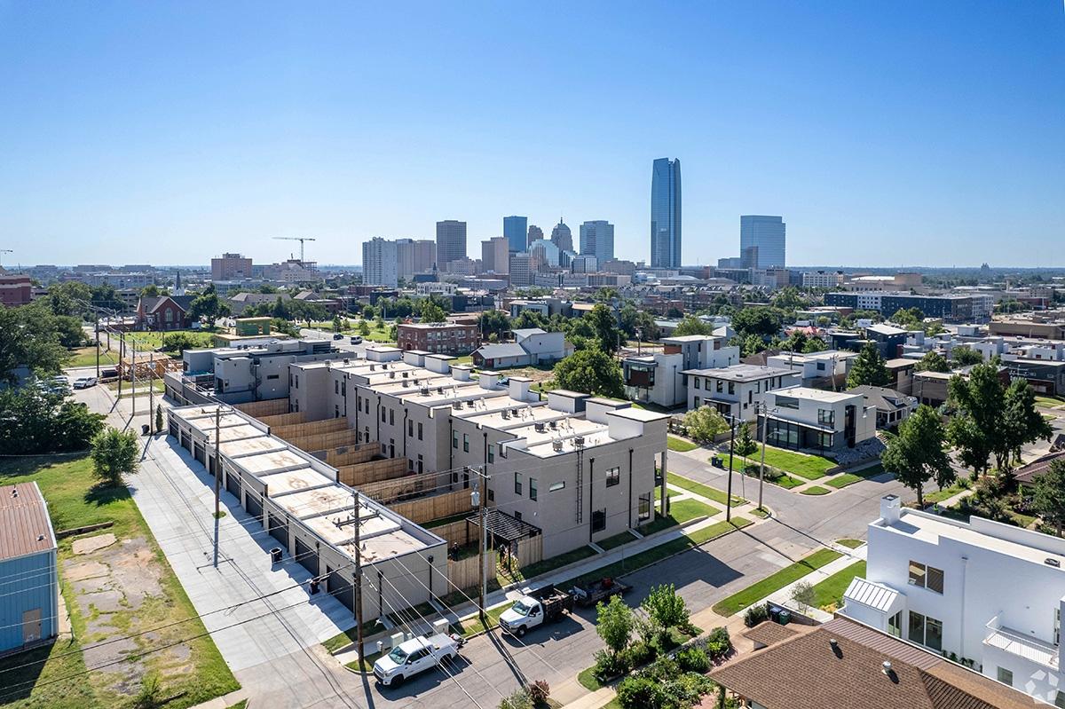 Townhomes and apartment buildings sit in Midtown with downtown rising in the background.